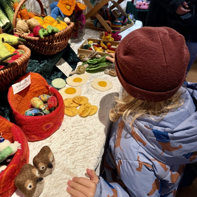 Ein Junge schaut sich Filzartikel auf dem Weihnachtsmarkt im Freilichtmuseum Kommern an